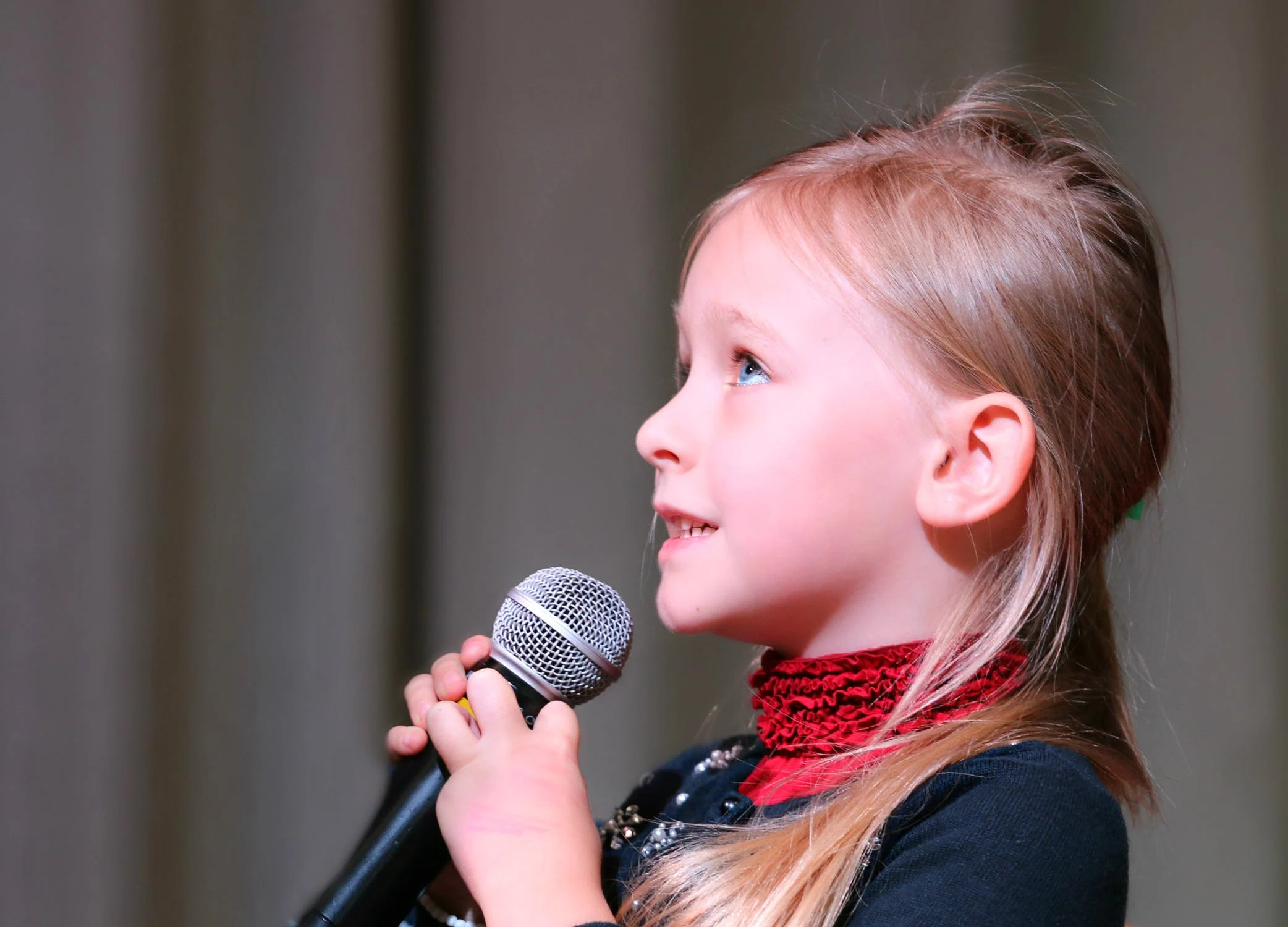 child holding a microphone and singing