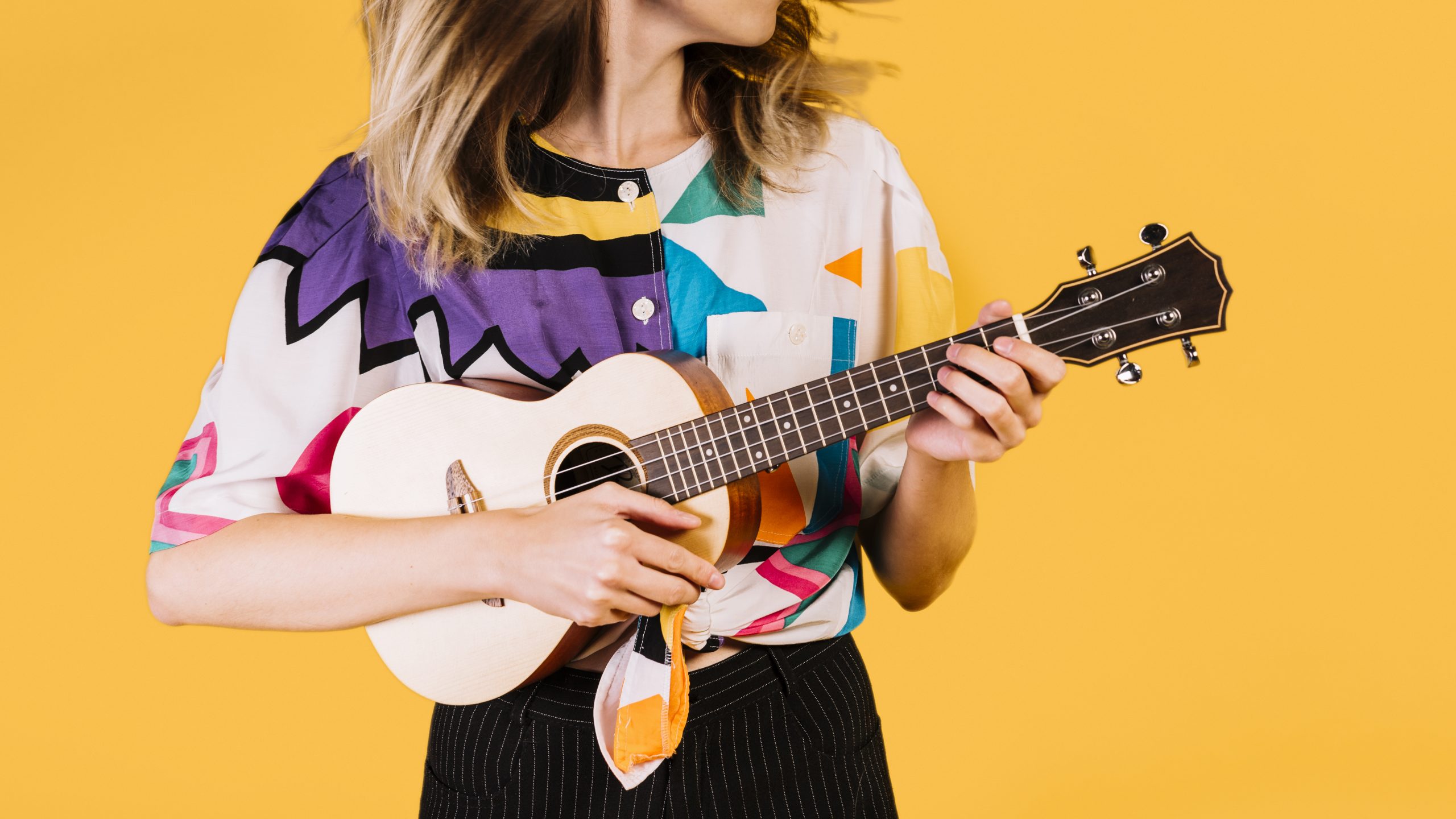 girl holding onto a ukulele